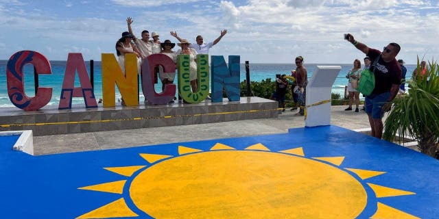 Tourists take pictures in Playa Delfines at the Hotel Zone of Cancun, Quintana Roo state, Mexico, on November 8, 2022.