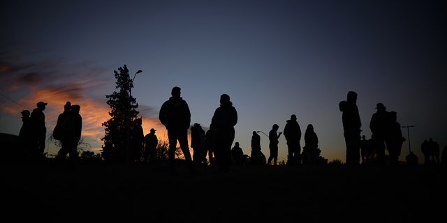Venezuelan migrants communicate with their families and friends at the camp area in front of the US Border Patrol operations post across the Rio Bravo River in the evening hours in Mexico on November 14, 2022. 