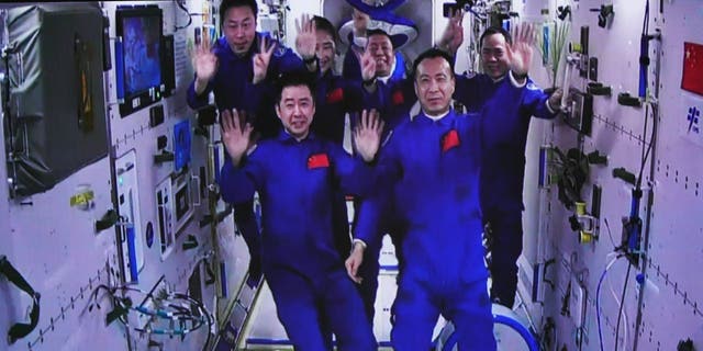 This image captured at the Jiuquan Satellite Launch Center in northwest China shows the crew of Shenzhou-15 and Shenzhou-14 waving after a historic rally in space on Nov. 30, 2022. The three astronauts aboard China's Shenzhou- 15 entered the country's space station and met with another trio of astronauts Wednesday, a historic meeting that added the workforce of the orbiting space laboratory to six for the first time.   
