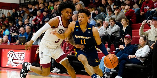 El escolta de los Quinnipiac Bobcats, Dezi Jones (11), regatea el balón contra el escolta de los Rider Broncs, Corey McKeithan (3), durante la primera mitad de un partido el 6 de enero de 2023 en el Alumni Gymnasium de Lawrenceville, Nueva Jersey.