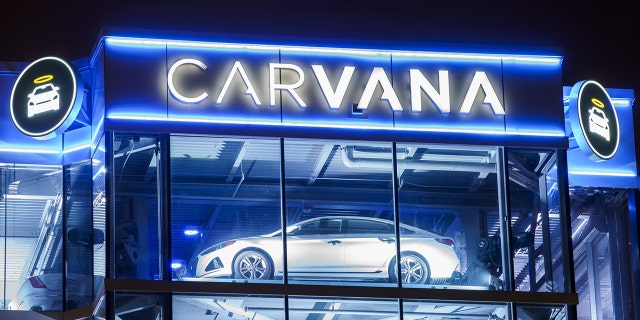 A Carvana glass tower sits illuminated on Feb. 23, 2022, in Oak Brook, Illinois.