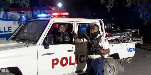 Policías patrullan la calle durante una vigilia en memoria de tres policías asesinados por bandas armadas, el 30 de enero de 2023, en Pétion-Ville, Puerto Príncipe, Haití.