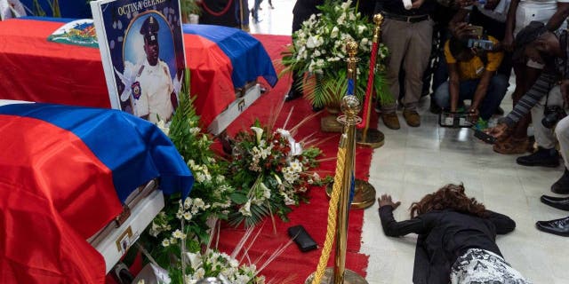 A woman cries near a coffin during the funeral of three police officers at the National Police School in Port-au-Prince, Haiti, January 31, 2023.