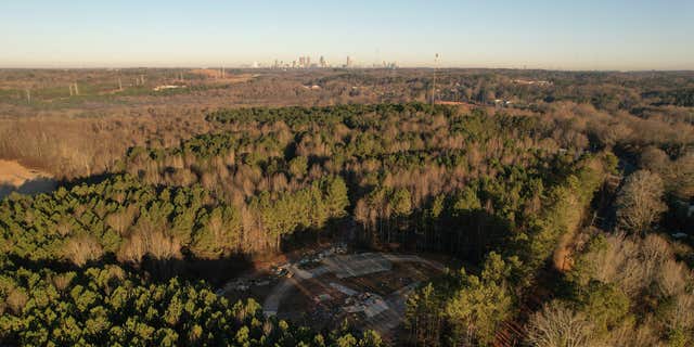 In this aerial view, law enforcement vehicles block the entrance to the planned site of a police training facility near Atlanta.