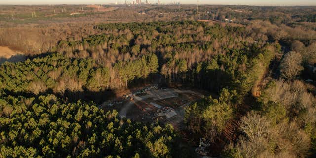 In this aerial view, law enforcement vehicles block the entrance to the planned site of a police training facility near Atlanta.