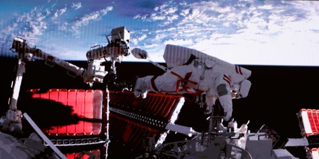 This screen image captured at Beijing Aerospace Control Center on Feb. 9, 2023, shows Shenzhou-15 taikonaut Fei Junlong returning to space station lab module Wentian with equipment. The Shenzhou-15 taikonauts on board the orbiting Chinese Tiangong space station completed their first spacewalk at 12:16 a.m. Beijing Time on Friday, according to the China Manned Space Agency. 