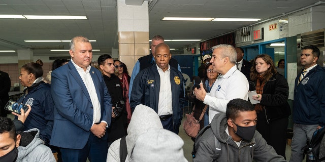 Mayor Eric Adams, center, seen helping to distribute donated food and clothing to families of asylum seekers in the city at Public School 20 Anna Silver School. On Tuesday, he unveiled a blueprint for addressing the migrant crisis.