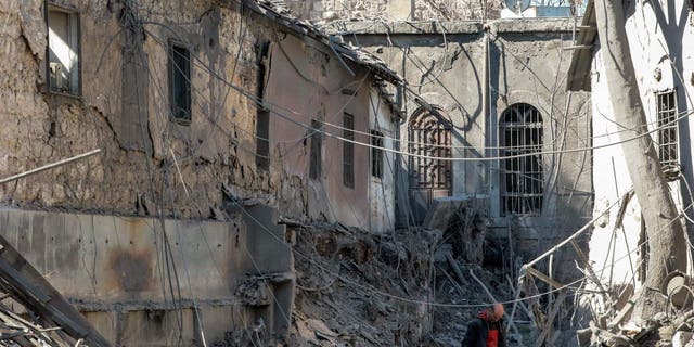 People inspect damage in the aftermath of an Israeli air strike that hit the medieval Citadel of Damascus Feb. 19, 2023. 