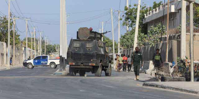 Security forces patrol outside a building which was attacked by suspected al-Shabab militants in the Somalia's capital on Feb. 21, 2023. The United States sent military assistance to Somalia to help fend off the al-Shabab.