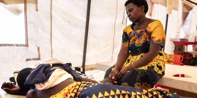 Un funcionario africano de la OMS insta a más apoyo para los países que enfrentan un brote de cólera 4 Una mujer sostiene la mano de su hijo en un centro temporal de tratamiento del cólera en un hospital de Lilongwe el 21 de febrero de 2023. Un funcionario de la Organización Mundial de la Salud insta a que se preste más apoyo a los países que experimentan brotes de cólera.
