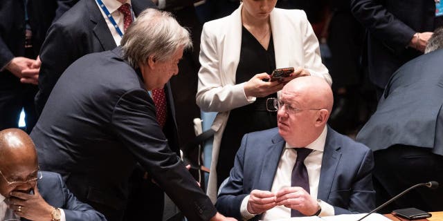 Secretary-General Antonio Guterres speaks with Ambassador of Russia Vassily Nebenzia before the start of the Security Council meeting on Ukraine at U.N. headquarters, Feb. 24, 2023.