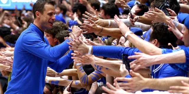 Duke Blue Devils head coach Jon Scheyer high-fives the Cameron Crazies following their game against the NC State Wolfpack at Cameron Indoor Stadium on Feb. 28, 2023 in Durham, North Carolina. Duke won 71-67.