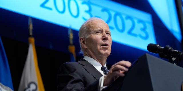 President Joe Biden speaks in front of podium
