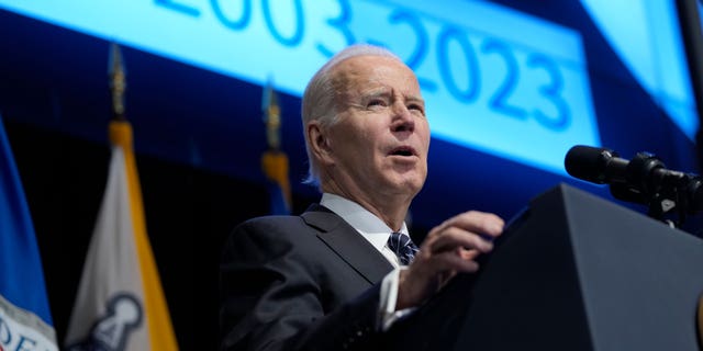 President Joe Biden speaks in front of podium