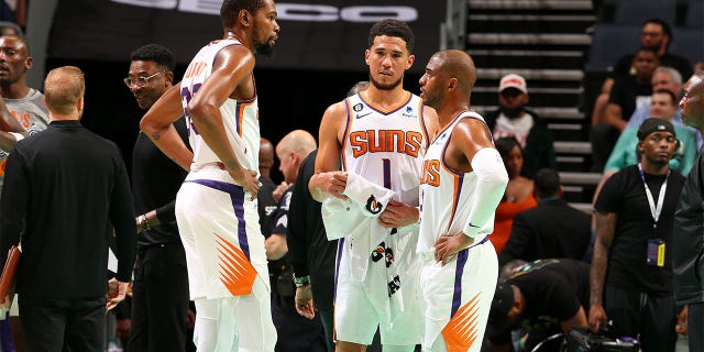 Kevin Durant, left, talks to Devin Booker (1) and Chris Paul (3) of the Phoenix Suns during a game against the Charlotte Hornets March 1, 2023, at Spectrum Center in Charlotte, N.C.