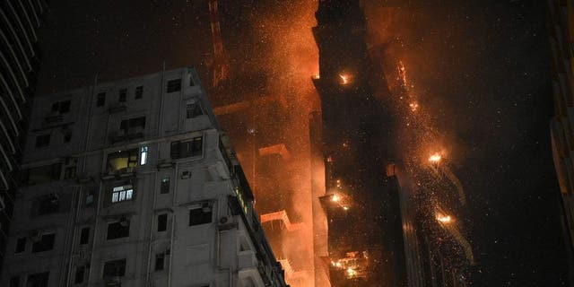 A fire burns at a high-rise building under construction in the Tsim Sha Tsui district in Hong Kong on March 3, 2023.