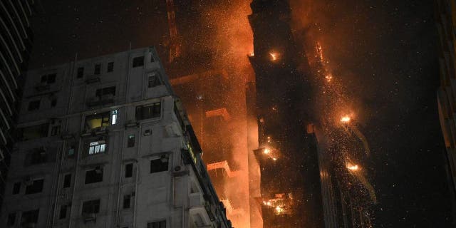 A fire burns at a high-rise building under construction in the Tsim Sha Tsui district in Hong Kong on March 3, 2023.