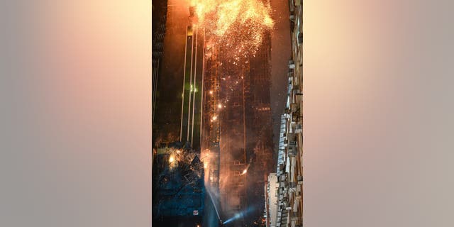 A fire burns at a high-rise building under construction in the Tsim Sha Tsui district in Hong Kong on March 3, 2023.