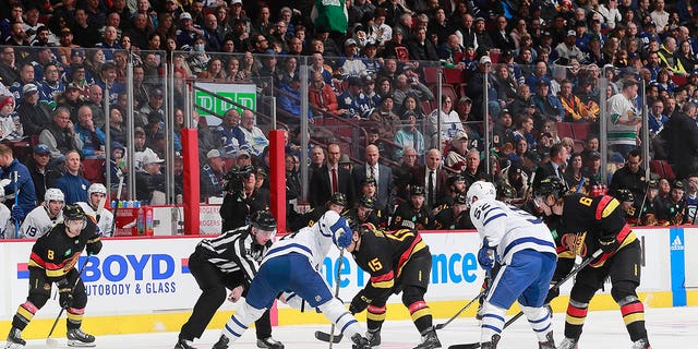 Sheldon Dries (15) de los Vancouver Canucks y Ryan O'Reilly (90) de los Toronto Maple Leafs abordan un touchdown durante el primer tiempo de un partido en el Rogers Arena el 4 de marzo de 2023 en Vancouver, Columbia Británica, Canadá.  