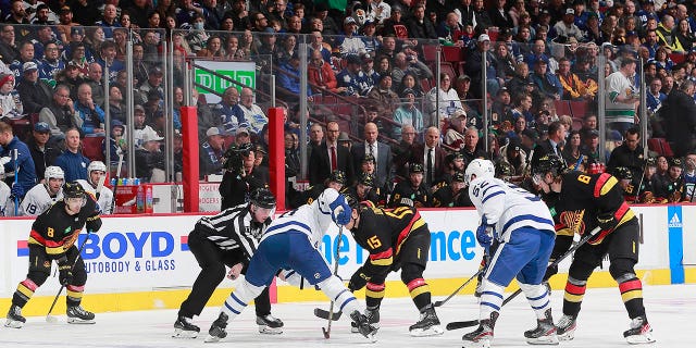 Sheldon Dries (15) de los Vancouver Canucks y Ryan O'Reilly (90) de los Toronto Maple Leafs abordan un touchdown durante el primer tiempo de un partido en el Rogers Arena el 4 de marzo de 2023 en Vancouver, Columbia Británica, Canadá.