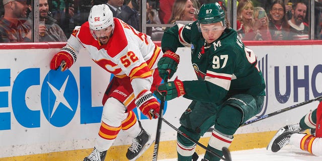 Kirill Kaprizov, #97 of the Minnesota Wild, skates with the puck while MacKenzie Weegar, #52 of the Calgary Flames, defends during the game at the Xcel Energy Center on March 7, 2023 in Saint Paul, Minnesota.