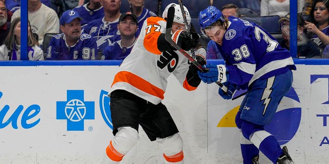 El defensa de los Philadelphia Flyers, Tony DeAngelo, #77, y el ala izquierda de los Tampa Bay Lightning, Brandon Hagel, #38, durante el partido de hockey de la NHL entre los Tampa Bay Lightning y los Philadelphia Flyers el 7 de marzo de 2023 en el Amalie Arena de Tampa, Florida.