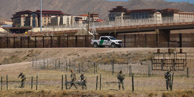 National Guard agents place a barbed wire wall on the banks of the Rio Grande in El Paso, Texas, on the border with Ciudad Juarez, Chihuahua State, Mexico, on March 8, 2023.
