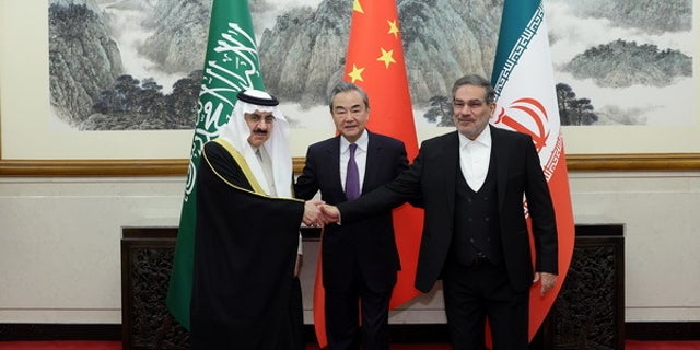 Iranski najviši sigurnosni dužnosnik, Ali Shamkhani, desno, kineski ministar vanjskih poslova Wang Yi, sredina, i Musaid Al Aiban, savjetnik za nacionalnu sigurnost Saudijske Arabije, rukuju se nakon što su Iran i Saudijska Arabija pristali obnoviti bilateralne diplomatske odnose u Pekingu 10. ožujka 2023.
