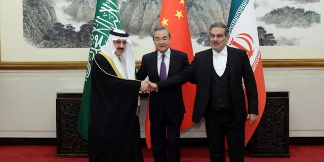 Iran's top security official, Ali Shamkhani, right, Chinese Foreign Minister Wang Yi, center, and Musaid Al Aiban, Saudi Arabia's national security adviser, shake hands after Iran and Saudi Arabia agreed to resume bilateral diplomatic ties in Beijing on March 10, 2023.