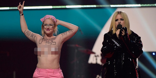 The topless woman interrupted Lavigne while she was introducing a performance by Canadian-Punjabi singer AP Dhillon.