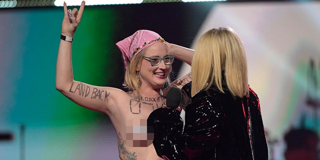 A protestor interrupts Avril Lavigne speaking onstage at the 2023 JUNO Awards at Rogers Place on March 13, 2023 in Edmonton, Canada. 