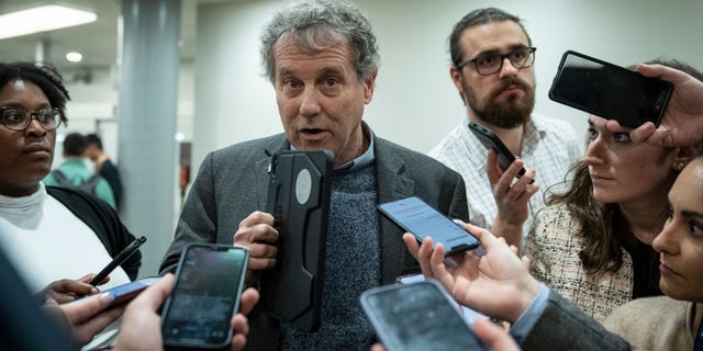 Sen. Sherrod Brown, D-Ohio, speaks to reporters in the Senate subway on his way to a vote at the U.S. Capitol March 14, 2023 in Washington, D.C.