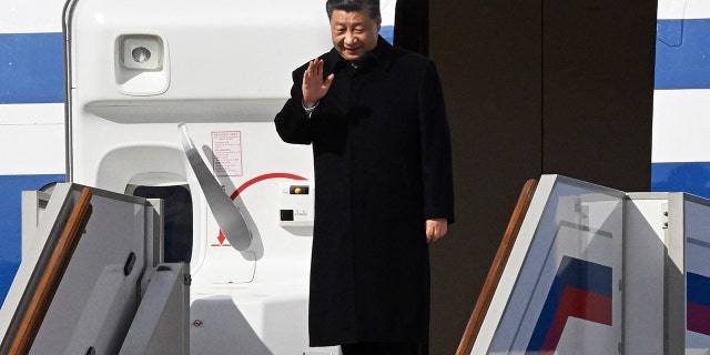 China's President Xi Jinping waves as he disembarks off his aircraft upon arrival at Moscow's Vnukovo airport on March 20, 2023. 