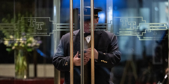 The doorman checks his cell phone at the entrance of Trump Tower in New York on March 20, 2023. 