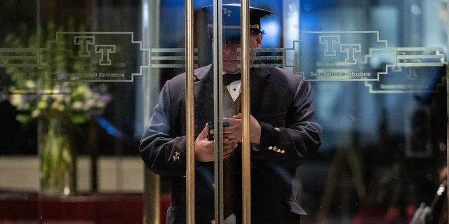 The doorman checks his cell phone at the entrance of Trump Tower in New York on March 20, 2023.