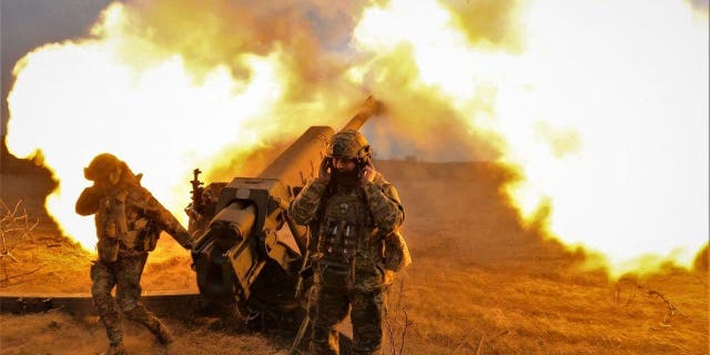 TOPSHOT - Ukrainian servicemen fire with a D-30 howitzer at Russian positions near Bakhmut, eastern Ukraine, on March 21, 2023, amid the Russian invasion of Ukraine. 