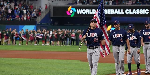 Mike Trout de los Estados Unidos lidera a sus compañeros mientras porta la bandera estadounidense antes de un partido contra Japón en el LoanDepot Park el 21 de marzo de 2023 en Miami, Florida. 