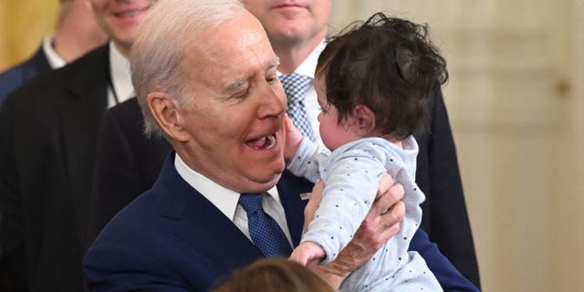 President Joe Biden holds a baby