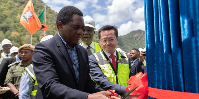 Zambian President Hakainde Hichilema cuts the ribbon as he attends the commissioning ceremony of the fifth generator of Zambia's Kafue Gorge Lower Hydroelectric Power Plant in Southern Province on March 24, 2023. 