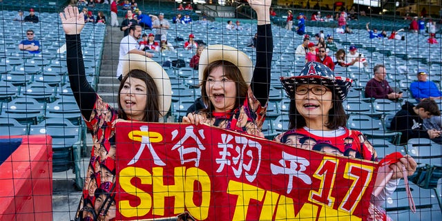 Shohei Ohtani fans, from left, Harue Boyle, Sae Koines and Eriko Inoue, wait to see their favorite player before a Freeway Series exhibition game between the Angels and Dodgers at Angel Stadium in Anaheim on Monday March 27, 2023. 
