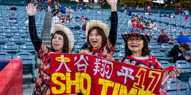 Los fanáticos de Shohei Ohtani, de izquierda a derecha, Harue Boyle, Sae Koines y Eriko Inoue, esperan ver a su jugador favorito antes de un juego de exhibición de la Serie Freeway entre los Angelinos y los Dodgers en el Angel Stadium en Anaheim el lunes 27 de marzo de 2023. 