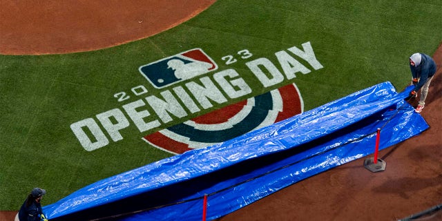 The tarp is removed to reveal the Opening Day logo before the 2023 Opening Day game between the Boston Red Sox and the Baltimore Orioles on March 30, 2023 at Fenway Park in Boston.