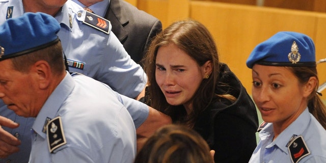 Amanda Knox, center, breaks down in tears after hearing the verdict that overturns her conviction and acquits her of murdering her British roommate Meredith Kercher, at the Perugia court on Oct. 3, 2011 in Perugia, Italy. 