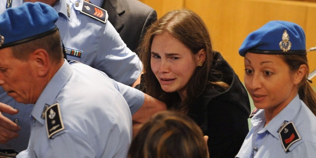 Amanda Knox, center, breaks down in tears after hearing the verdict that overturns her conviction and acquits her of murdering her British roommate Meredith Kercher, at the Perugia court on Oct. 3, 2011 in Perugia, Italy.
