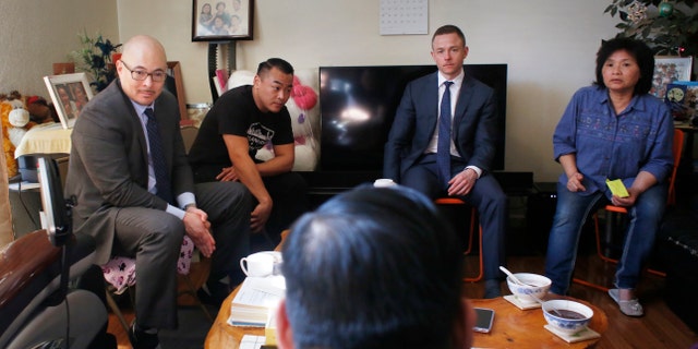 John Hamasaki (back left), attorney for Lam family, meets in the Lam family home during an interview on Sunday, March 12, 2017, in Oakland, Calif.