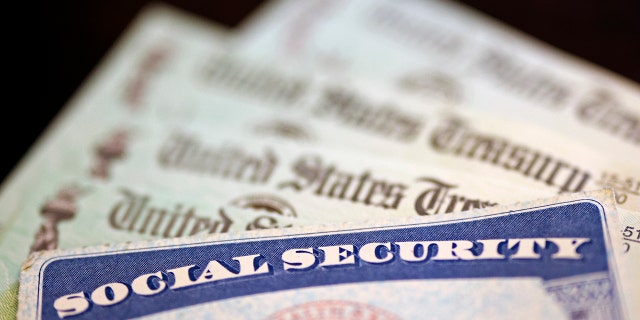 In this photo illustration, a Social Security card sits alongside checks from the U.S. Treasury on October 14, 2021 in Washington, DC.