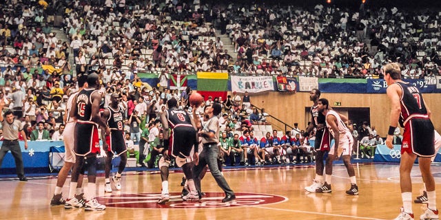 Patrick Ewing #6 of the U.S. Men's Olympic basketball team, known as the Dream Team, prepares for the jump ball to start a quarterfinal game against Puerto Rico on Aug. 4, 1992 at the Pavello Olimpic de Badalona in Barcelona, Spain; other visible players include Larry Bird #7, Karl Malone #11, Michael Jordan #9, and Magic Johnson #15. The USA won by a score of 115-77.