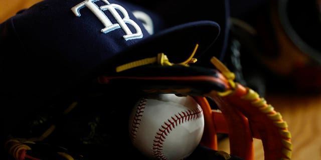 Detailed view of a Tampa Bay Rays hat, glove and MLB baseball during the first inning of the game against the Baltimore Orioles at Tropicana Field on Aug. 13, 2022 in St Petersburg, Florida.