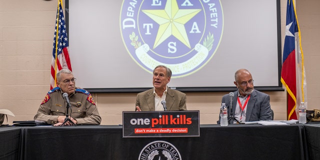 Texas Gov. Greg Abbott, center, speaks at a news conference on October 17, 2022, in Beaumont, Texas.
