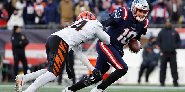 Vonn Bell #24 of the Cincinnati Bengals pressures Mac Jones #10 of the New England Patriots as he attempts a pass during the fourth quarter at Gillette Stadium on December 24, 2022 in Foxborough, Massachusetts.
